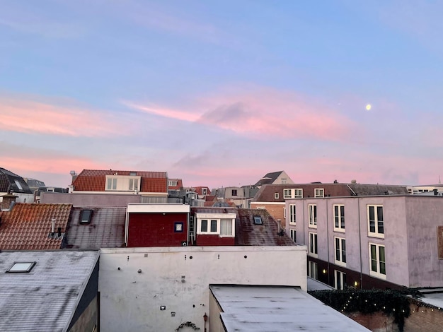 Photo houses in town against sky during sunset