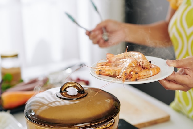 Housewife boiling shrimps