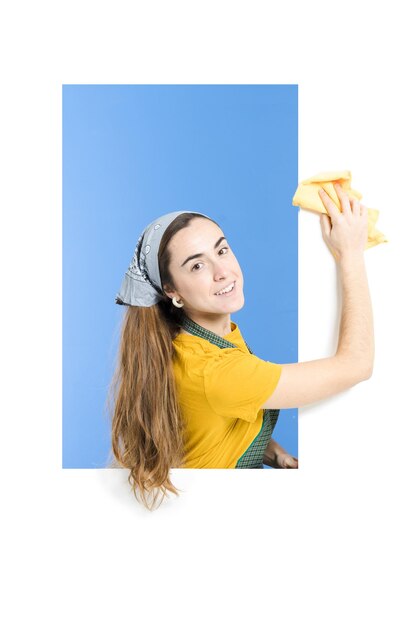 Housewife cleaning dust from the white wall