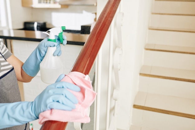 Housewife cleaning stair railing