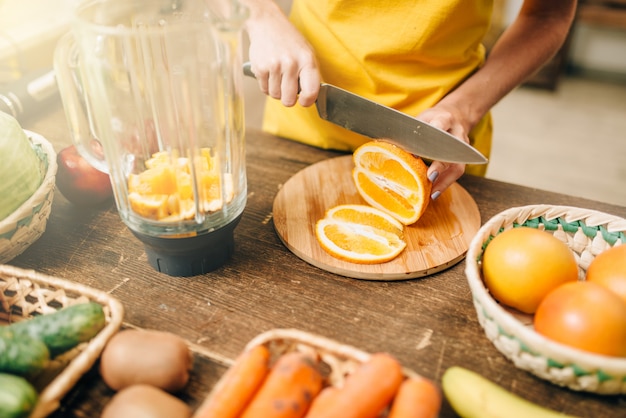 Домохозяйка готовит апельсиновый сок, натуральные продукты.