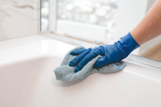 Housewife in gloves washes a bathroom