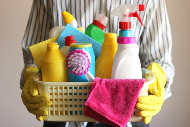 Housewife holds a basket with cleaning and disinfection products