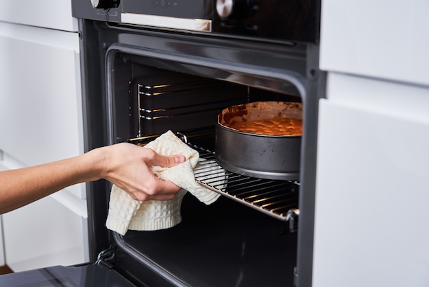 Housewife prepares cake in kitchen.