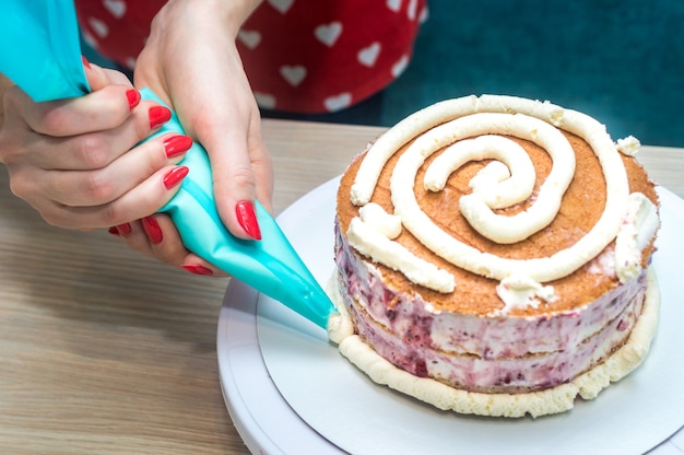 Housewife prepares sponge cake in the kitchen. Close-up. Woman's hands