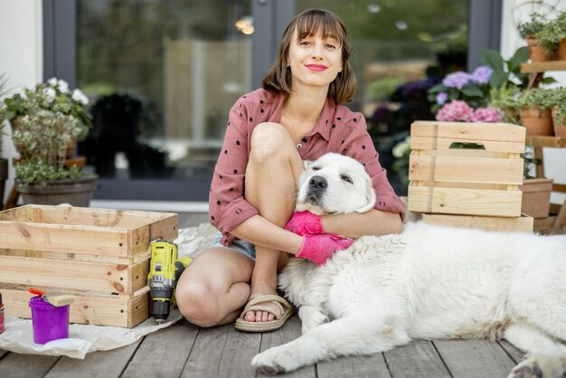 Housewife repairs wooden boxes on terrace