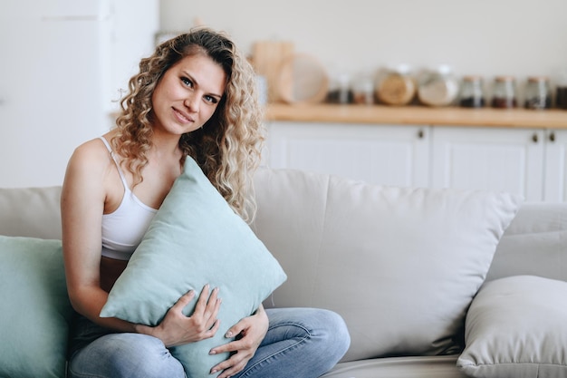 Housewife Sits Home on Cozy Sofa Hugging Pillow Free time for yourself