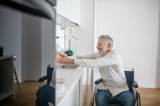 Foto lavori di casa. uomo disabile maturo a casa che fa alcuni lavori domestici