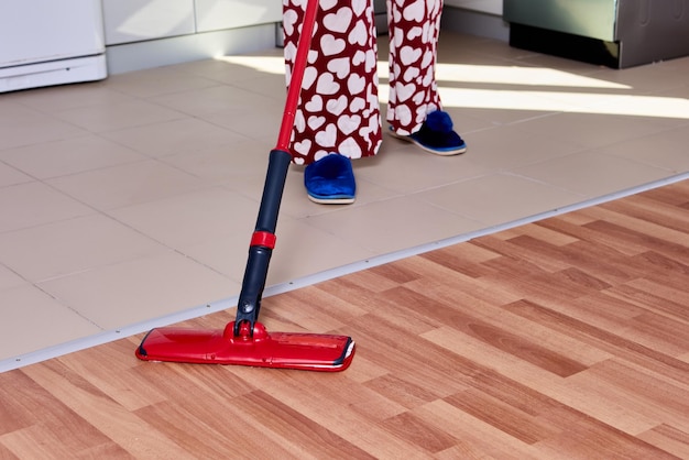 Housework with using flat mop to mopping floor in kitchen