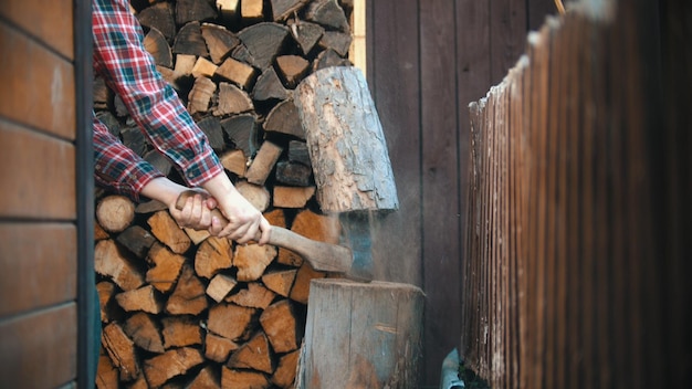 Hout hakken met een bijl in houtstapel