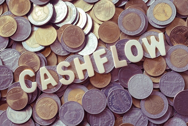 hout tekst CASHFLOW op munten achtergrond, business en finance concept