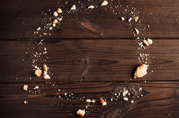 houten achtergrond met kruimels van cookies in de vorm van een cirkel, kopie ruimte