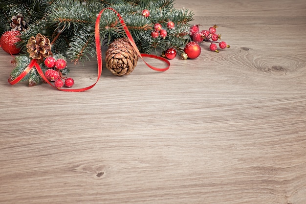 Houten achtergrond met versierde kerstboomtakjes