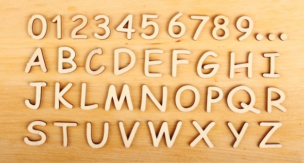 Houten alfabet en cijfers in volgorde op de houten achtergrond