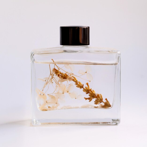 Houten aroma sticks in een glazen kolf gevuld met smaak vloeibare stof geïsoleerd over witte achtergrond zijweergave foto van hoge kwaliteit