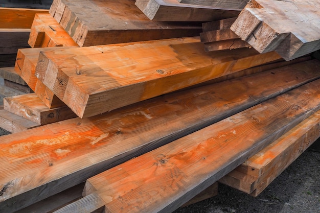 Houten balken zijn bedekt met roestwerend middel. Het brandwerend maken van houten constructies. Houten planken gestapelde stapel.