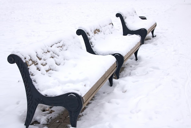 Houten bankje onder de sneeuw in het park