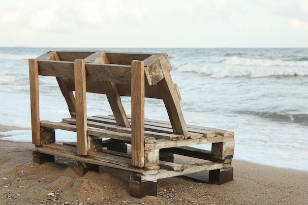 Houten bankje op prachtig zandstrand aan zee