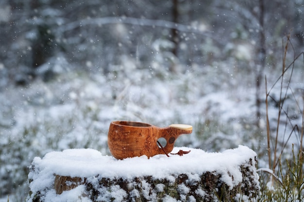 Houten beker met koffie in de sneeuw