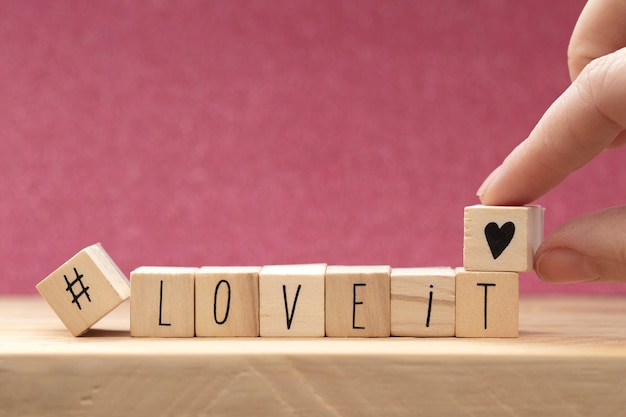 Houten blokjes met een hashtag en de woorden love it, social media concept achtergrond