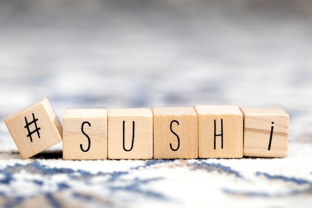 Houten blokjes met een hashtag en het woord Sushi, social media en food concept