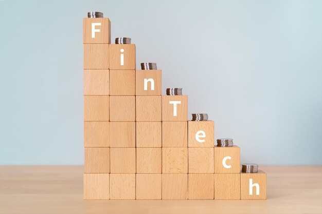 Houten blokken met FINTECH-tekst van concept en munten.