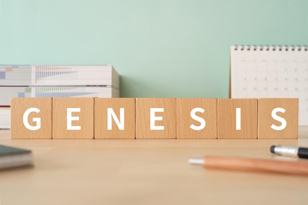 Houten blokken met GENESIS-tekst van concept, pennen, notitieboekjes en boeken.