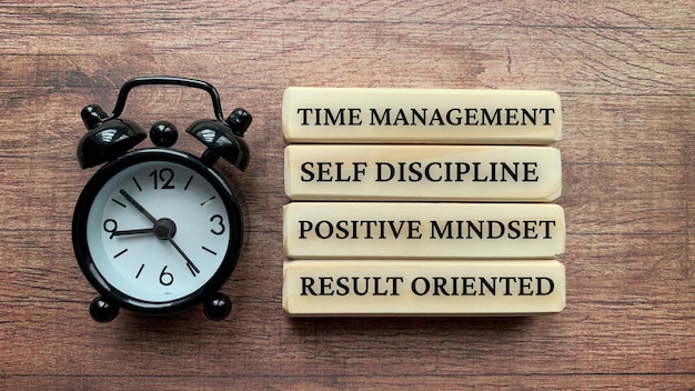 Foto houten blokken met tekst time management zelfdiscipline positieve mindset resultaatgericht bedrijfsconcept