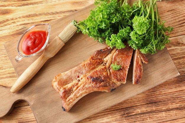 Houten bord met heerlijke gegrilde ribben op tafel