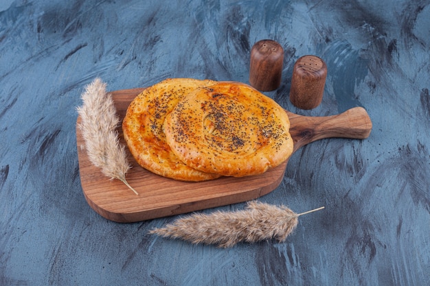 Houten bord met heerlijke geurige gebakjes op marmer.