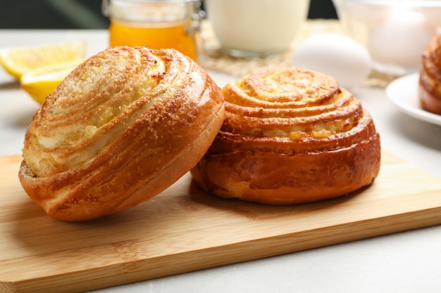 Houten bord met lekkere broodjes op tafel close-up Vers uit de oven