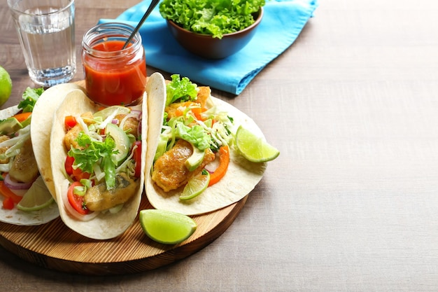 Houten bord met lekkere vistaco's op tafel