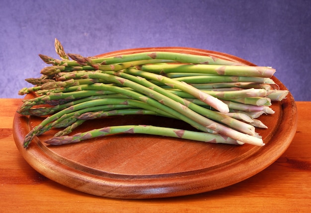 houten bord met rauwe asperges