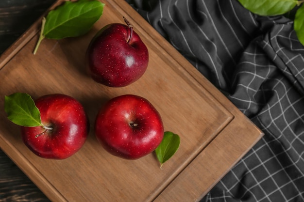 Houten bord met rijpe rode appels op tafel