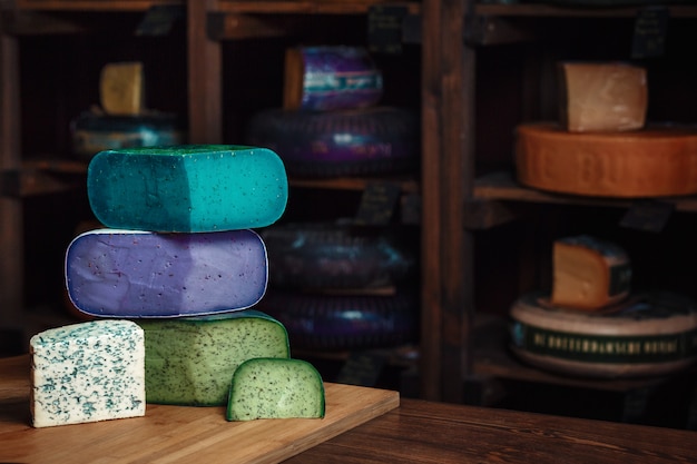 Houten bord met verschillende soorten heerlijke kaas blauw groen violet kaas met schimmel op de tafel