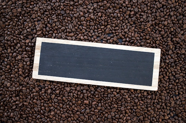 Houten bord warme koffie en bonen op houten tafel achtergrond