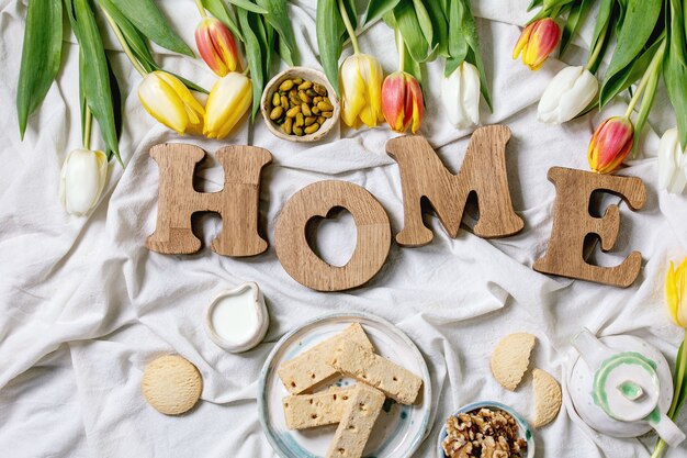 Houten brievenHUIS op een lijst met tulpenbloemen en ontbijt