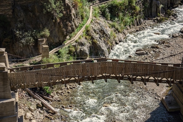 Houten brug over de rivier in de Kalash-vallei in Noord-Pakistan
