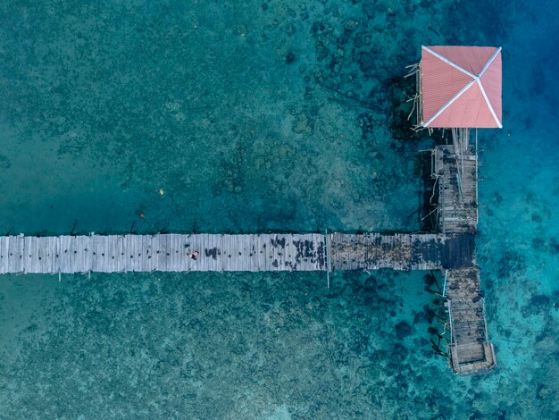 Houten brug over een prachtig strand in Maluku, Indonesië