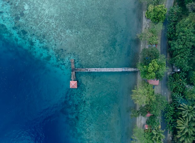houten brug over een prachtig strand in Maluku