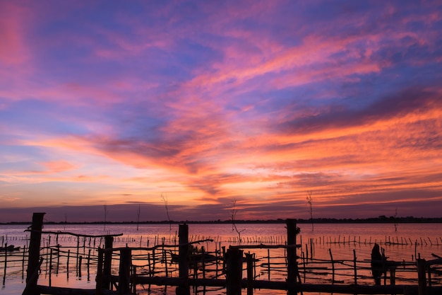 houten brugstructuur in het meer met zonsondergangachtergrond.