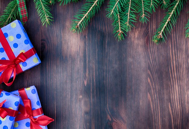 Houten bruin oppervlak met takken van vuren en verpakte geschenken