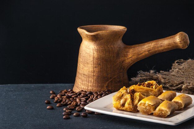 Houten cezve met baklava op de donkere tafel horizontaal