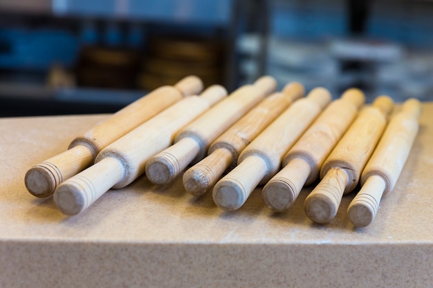 Houten deegroller op de tafel close-up. Apparatuur voor het maken van pizza