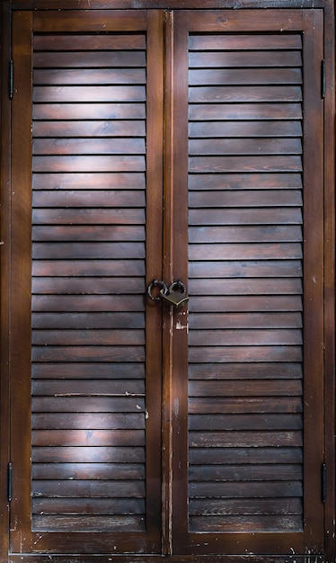 Houten deur met ventilatie van lamellen zonwerende jaloezieën deur gesloten met een hangslot close-up verticaal frame