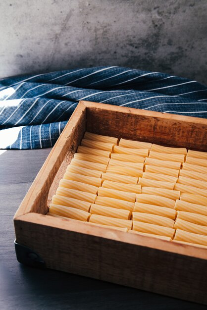 Houten dienblad met bestelde rauwe rigatoni