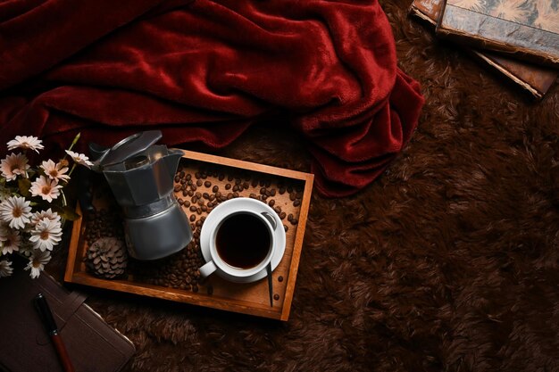 Houten dienblad met moka pot koffiekopje en gebrande koffiebonen op bruin tapijt