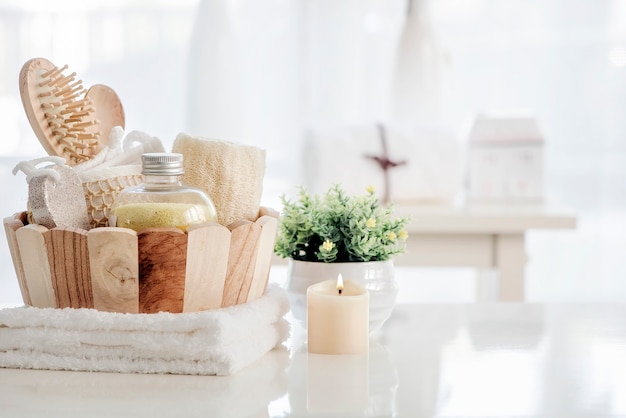 Houten emmer met spa-accessoires op witte tafel.