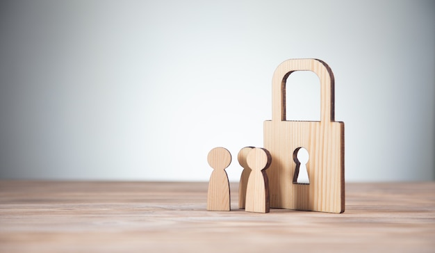 Houten figuren van mensen en slot op tafel