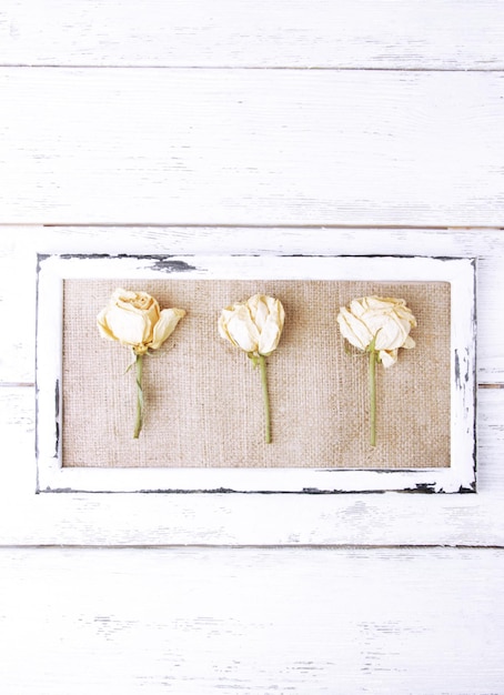 Houten frame met gedroogde bloemen op houten achtergrond